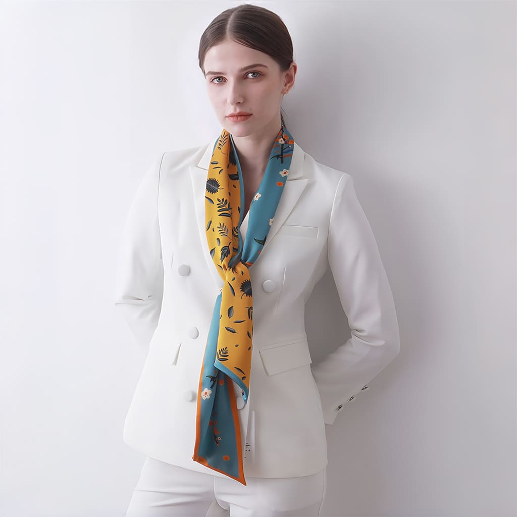 Woman wearing a white suit with a colorful scarf on a plain background