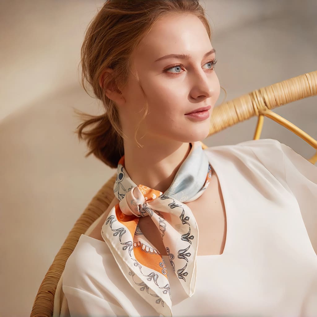 Woman wearing a patterned scarf sitting in a wicker chair.